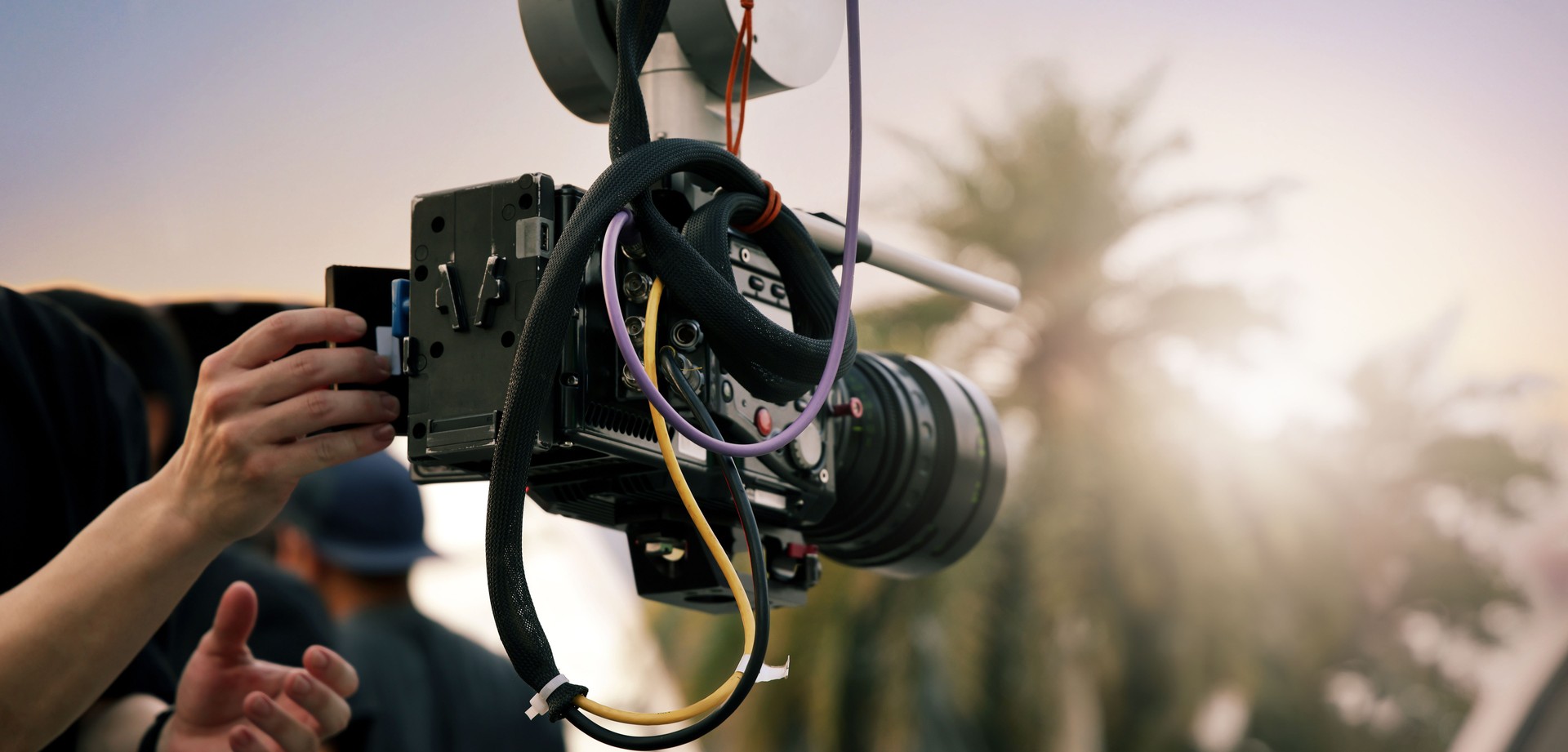 Video or film production with high tech robotic arm equipped with a professional cinema camera. Operated by a cinematographer. Advanced motion control system enables precise camera movements filming.
